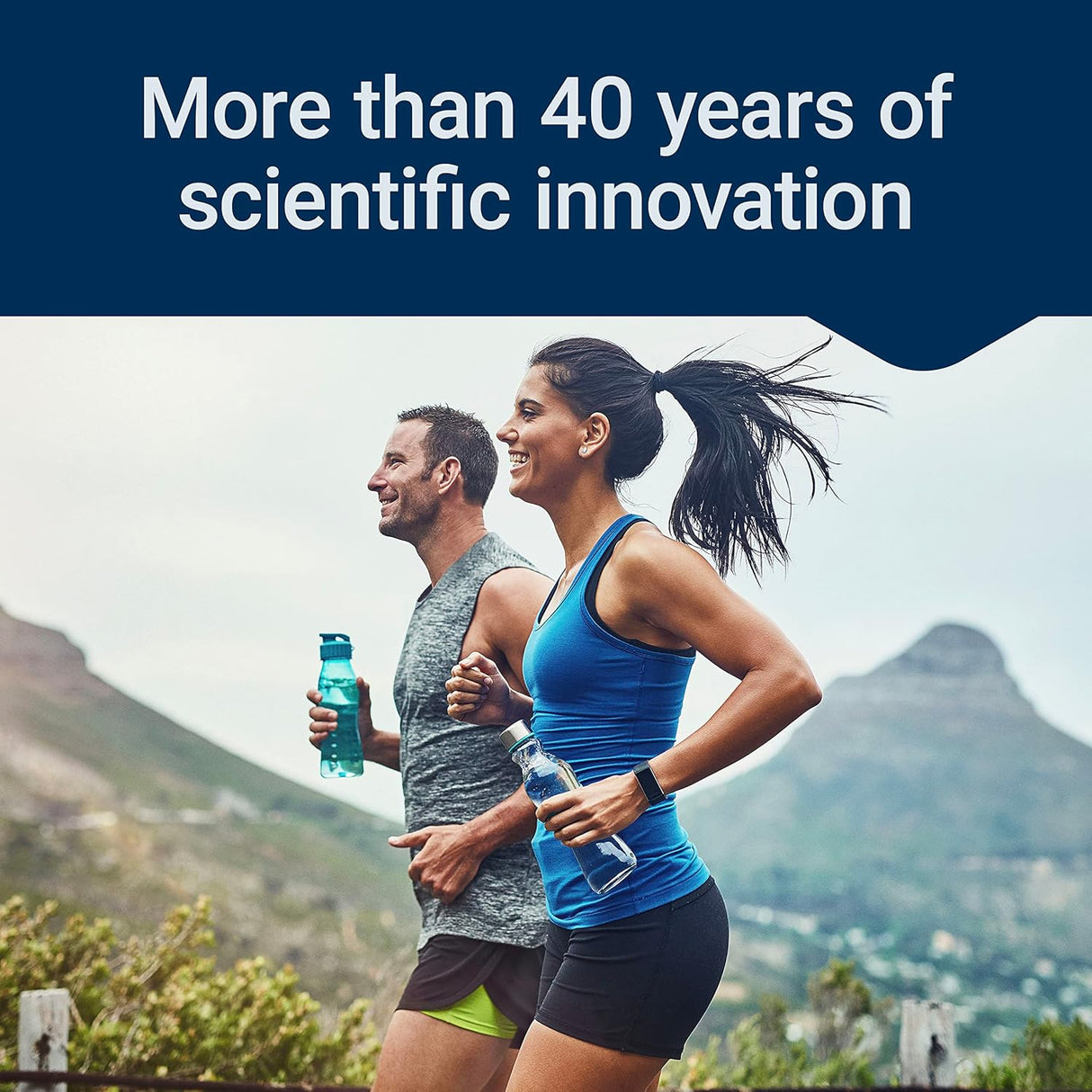 Deux hommes et femmes faisant du jogging dans la nature. La femme porte un maillot d'entraînement bleu et un short noir, tandis que l'homme porte une chemise de sport grise et un short court. Les deux contiennent des bouteilles d’eau.