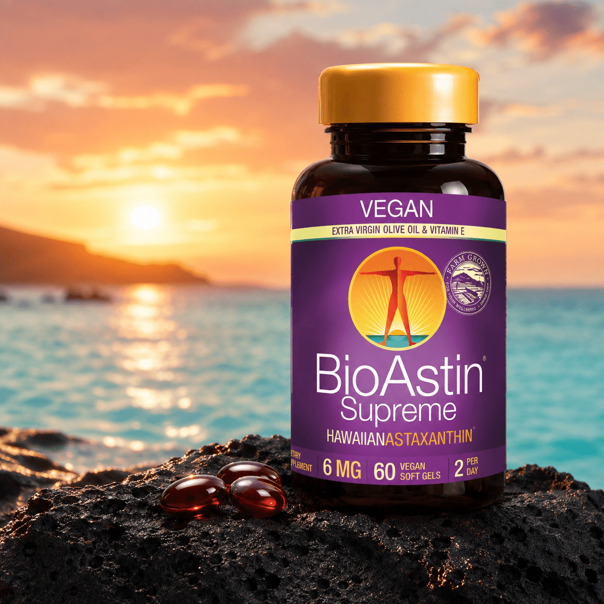 BioAstin Supreme astaxanthin i en brun plastflaska med gult lock, sex röda softgels på svart sten, horisont med solnedgång.