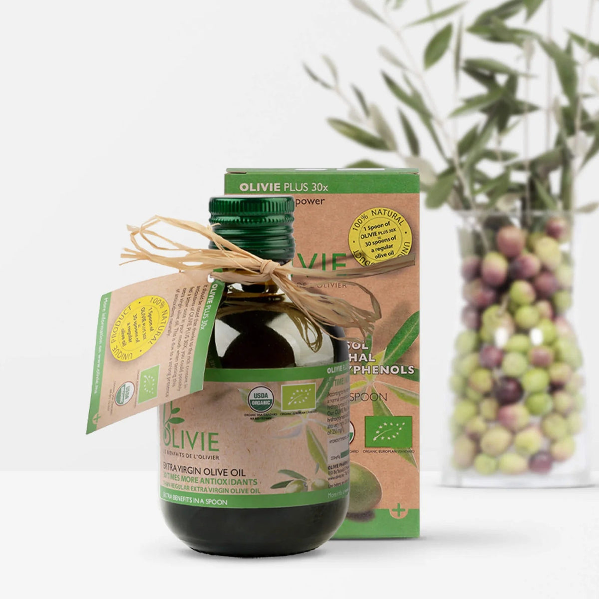 OLIVIE Plus 30x, a 250 ml dark glass bottle with a green screw cap, marked with organic symbols and a string.
