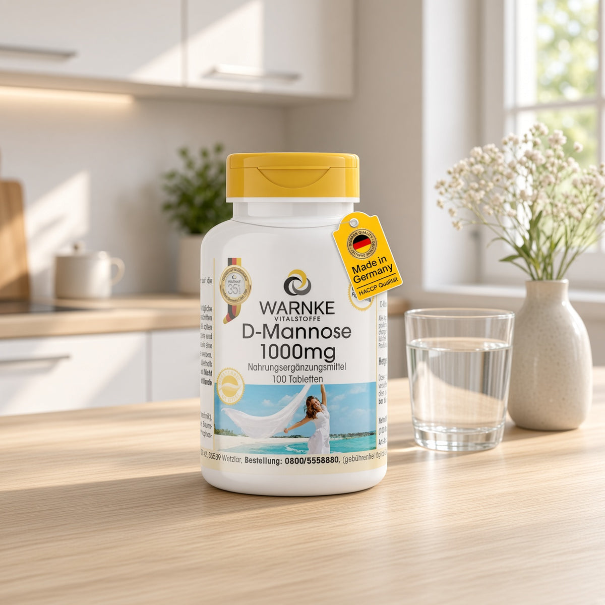 D-Mannose 1000 mg tabletter i en hvid flaske med gul låg, placeret på et lyst bord ved siden af ​​et glas vand.