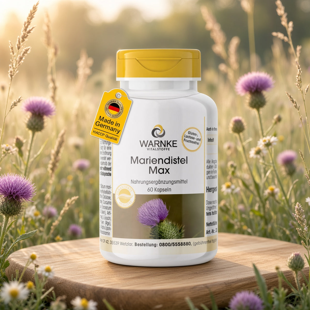 Récipient Max de chardon-Marie avec corps blanc et bouchon à vis jaune, placé sur une surface en bois avec des fleurs violettes en arrière-plan.