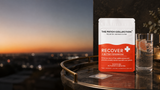 Compact pack of 15 Recover Patches, placed on a table surface, with a drink in the background.
