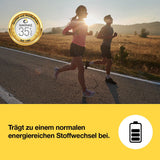 Kvinde og mand jogger på vejen med solopgang i baggrunden, i sporty outfits og kondisko.