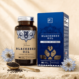 Huile de graines noires de qualité supérieure dans une bouteille en verre marron avec bouchon argenté et boîte bleue, entourée de graines noires et de fleurs.