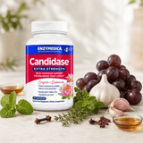 Candidase® Extra Strength food supplement in a white bottle with a blue label, surrounded by garlic, grapes and herbs.