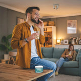 Man with brown shirt holding glass of lime drink in hand, with Go-Keto Hydrate container on table.