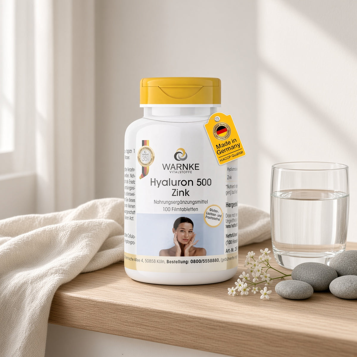 Hyaluron 500 + Zinc, 100 film-coated tablets with white packaging and yellow cap, displayed on a light wooden surface.