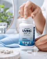 LIVING SILICA® kapsler i hvit vegetabilsk kapsel, pakket i en blå flaske, håndtert av en kvinne.
