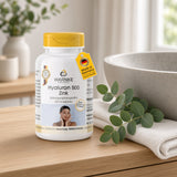 Hyaluron 500 + zinc in a white container with a yellow lid, 100 film-coated tablets, placed on a wooden surface by a washbasin.
