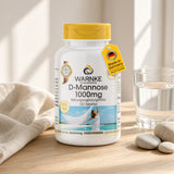 D-Mannose 1000 mg, 100 tabletter i en hvid flaske med gullig låg, placeret på et lyst trægulv ved siden af ​​et glas vand.